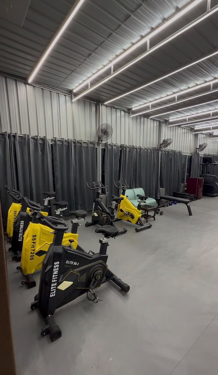 Indoor cycling zone with yellow and black bikes at Revive Fitnes